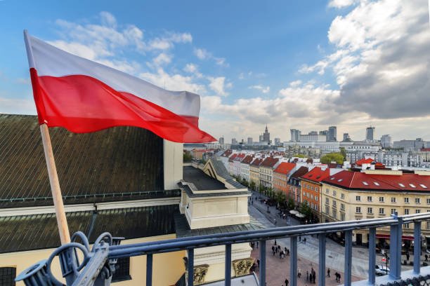 Poland Flag in Blue Sky and the centre of Warsaw in background Przekaż 1,5% podatku na OPP